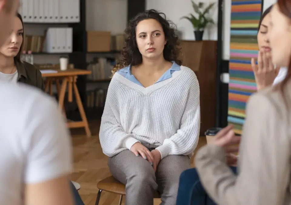 Kobieta zamyślona, być może przeżywająca trudne chwile, które mogą być objawami OCD. Grupa wsparcia.